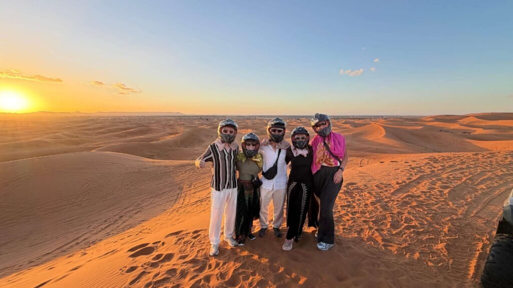 Travellers at sunset on the dunes of Merzouga